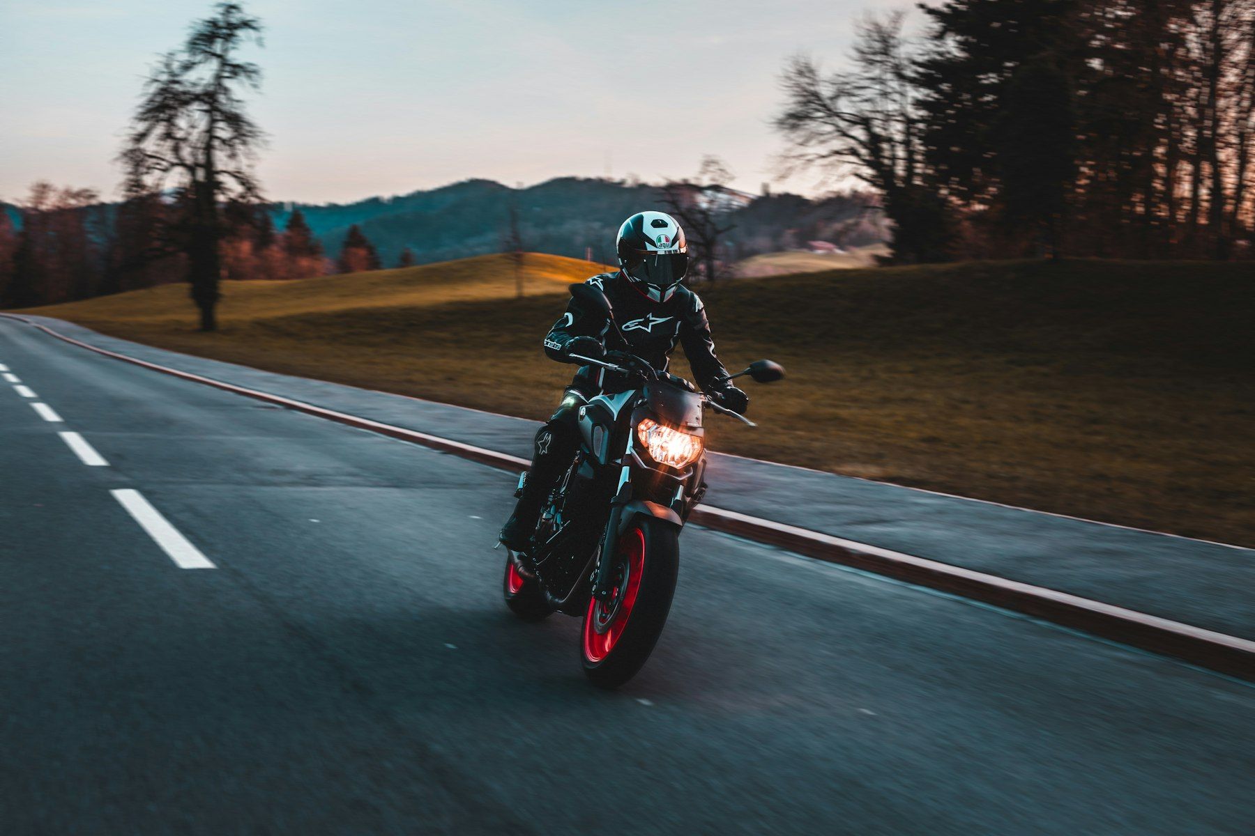 Motorradfahrer mit Helm auf einer Landstraße